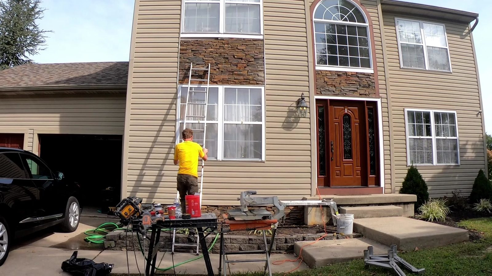 Crew installing stacked-stone veneer on a house front